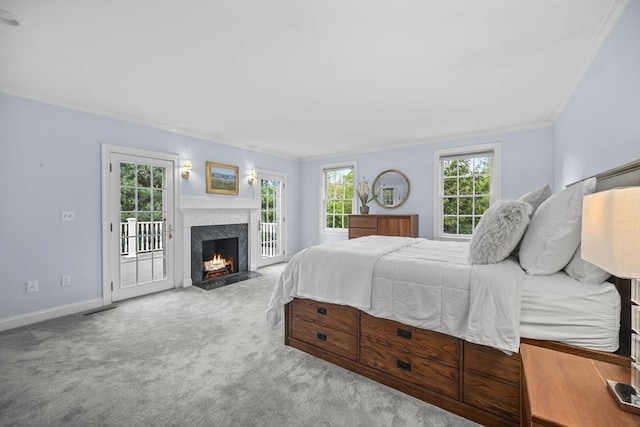 bedroom featuring access to outside, carpet, ornamental molding, a premium fireplace, and baseboards
