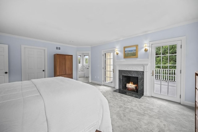 bedroom featuring access to exterior, multiple windows, a high end fireplace, light colored carpet, and ornamental molding