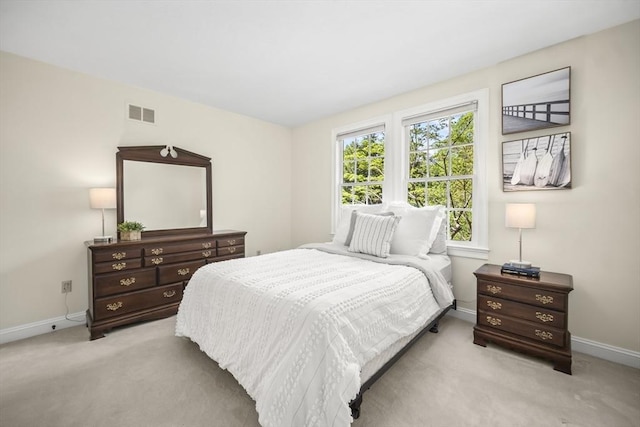 bedroom with light colored carpet and baseboards