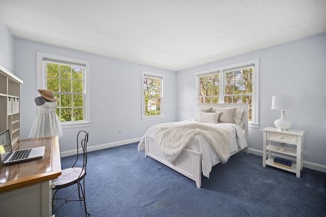 bedroom with dark colored carpet and baseboards