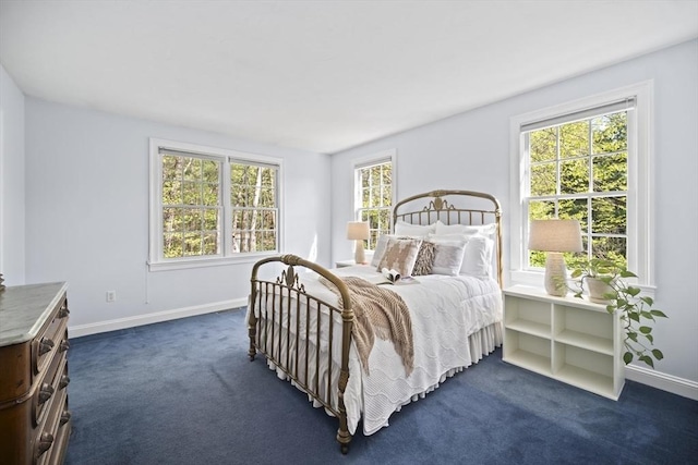 bedroom featuring dark colored carpet and baseboards