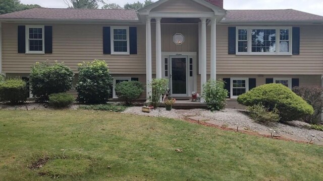 raised ranch featuring a front lawn