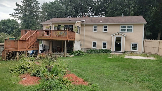 rear view of house featuring a deck and a lawn