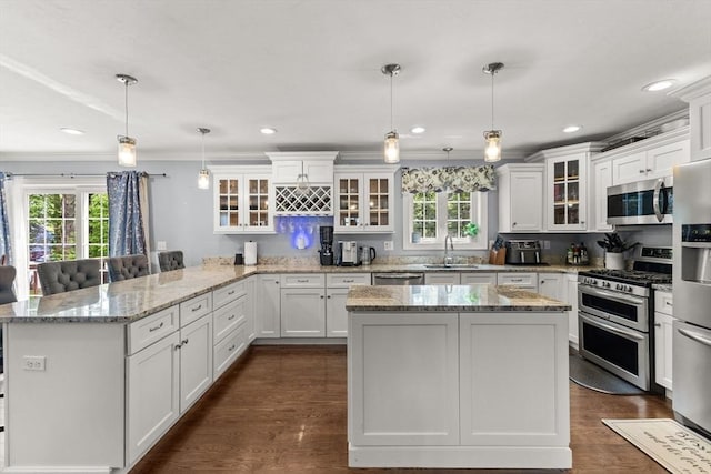 27 Nadias Way, Brockton, MA 02301 - kitchen featuring appliances with stainless steel finishes, a peninsula, a sink, white cabinetry, and crown molding