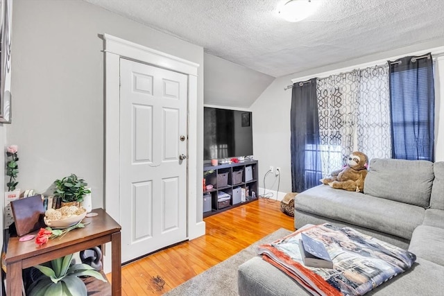 38 Cliff St, Fitchburg, MA 01420 - living area with wood finished floors, vaulted ceiling, and a textured ceiling