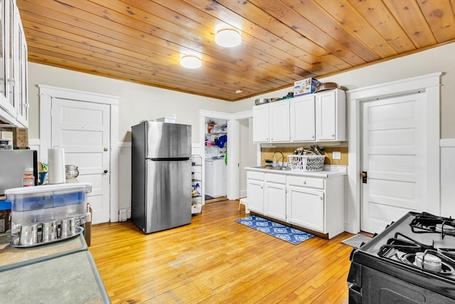 38 Cliff St, Fitchburg, MA 01420 - kitchen featuring freestanding refrigerator, black gas range oven, white cabinetry, light wood-style floors, and wooden ceiling