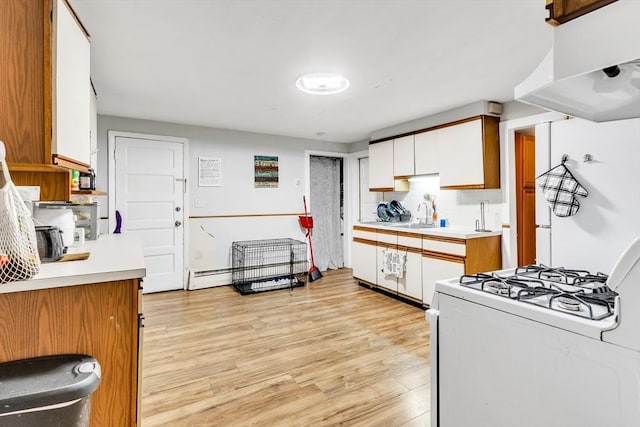38 Cliff St, Fitchburg, MA 01420 - kitchen featuring white gas range, light countertops, light wood-type flooring, white cabinetry, and decorative backsplash
