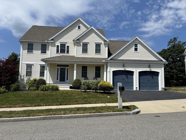 34 Winship Dr, Stoneham, MA 02180 - view of front of house with asphalt driveway, a garage, covered porch, a front yard, and a shingled roof