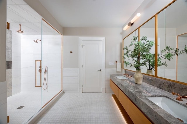 bathroom with a tile shower, vanity, and tile walls