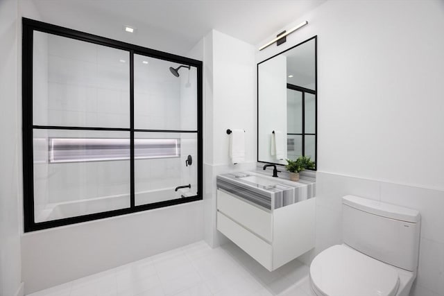 full bathroom featuring enclosed tub / shower combo, tile walls, vanity, and toilet