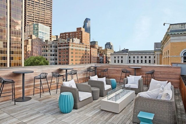 wooden deck with exterior bar and an outdoor living space with a fire pit