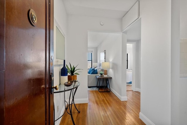 hallway featuring baseboards and light wood-style floors