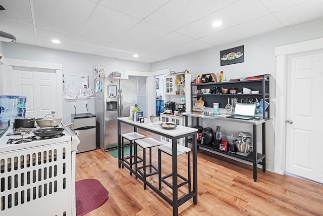 19 Chester St, Fitchburg, MA 01420 - kitchen with stainless steel refrigerator with ice dispenser, a drop ceiling, light wood-style floors, range with gas stovetop, and recessed lighting