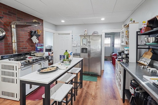 19 Chester St, Fitchburg, MA 01420 - kitchen featuring stainless steel fridge with ice dispenser, white range with gas stovetop, wood finished floors, a paneled ceiling, and open shelves
