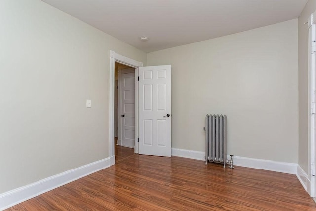 67 Alexander St, Springfield, MA 01107 - empty room featuring radiator heating unit, wood finished floors, and a smoke detector