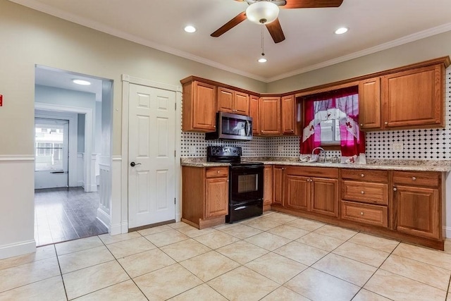 67 Alexander St, Springfield, MA 01107 - kitchen featuring electric range, stainless steel microwave, brown cabinets, ceiling fan, and tasteful backsplash