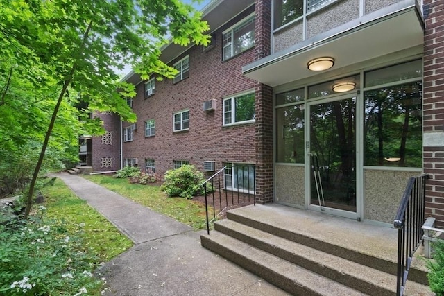 56 Jacqueline Rd Unit 12, Waltham, MA 02452 - view of exterior entry featuring brick siding and a wall mounted air conditioner