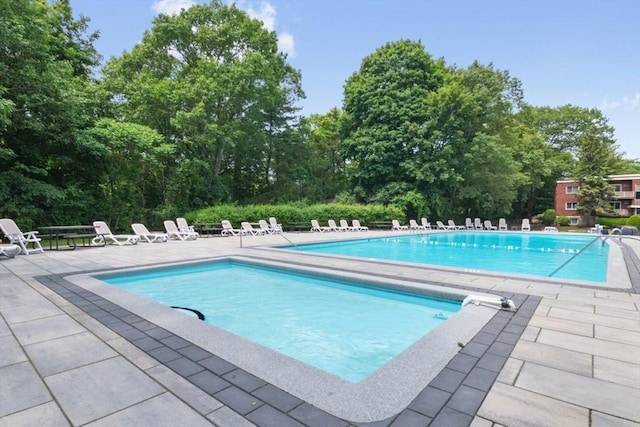 56 Jacqueline Rd Unit 12, Waltham, MA 02452 - community pool featuring a patio area and view of wooded area