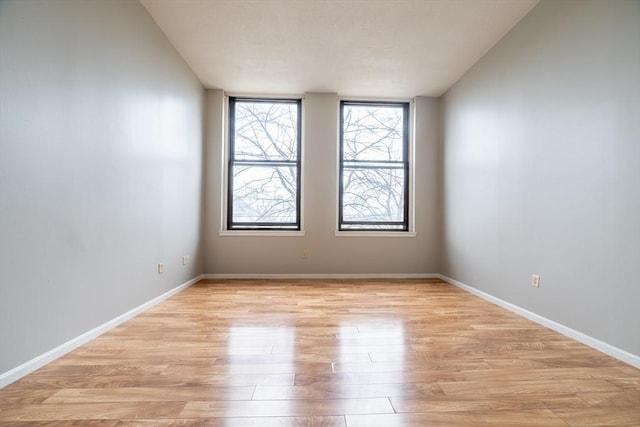 empty room featuring light wood finished floors and baseboards
