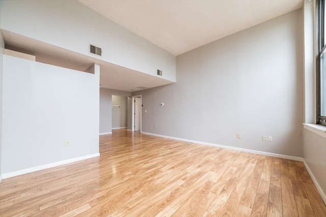 spare room featuring visible vents, baseboards, and light wood finished floors