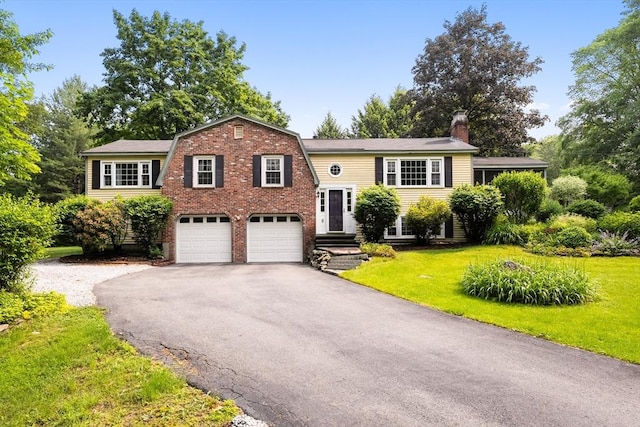 5 Ingalls Rd, Tyngsborough, MA 01879 - view of front of home with asphalt driveway, a chimney, a front lawn, brick siding, and a garage