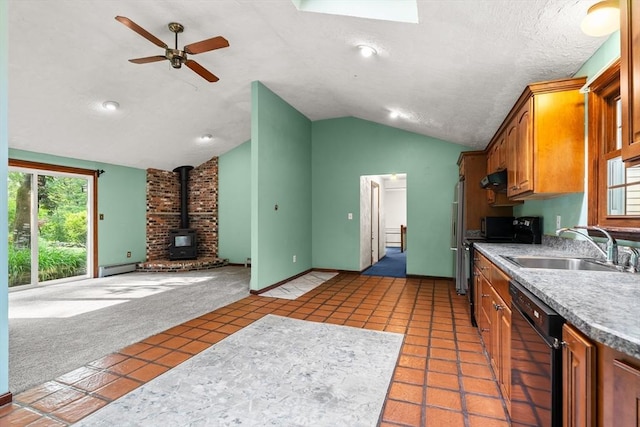 5 Ingalls Rd, Tyngsborough, MA 01879 - kitchen with black dishwasher, a wood stove, lofted ceiling, a baseboard heating unit, and brown cabinetry