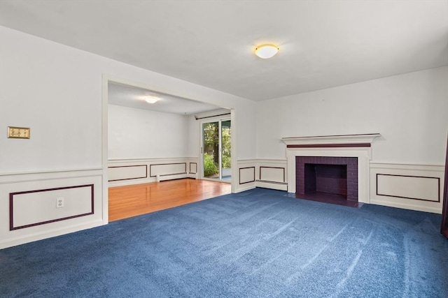 5 Ingalls Rd, Tyngsborough, MA 01879 - unfurnished living room featuring carpet, a decorative wall, a wainscoted wall, a brick fireplace, and baseboard heating