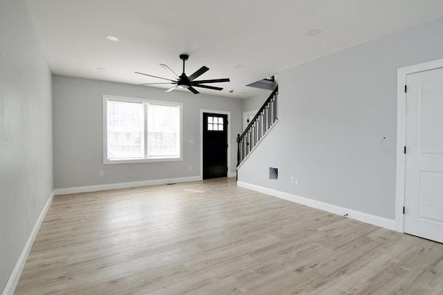 664 Mckinstry Ave, Chicopee, MA 01020 - unfurnished living room with a ceiling fan, stairway, light wood-style flooring, and baseboards