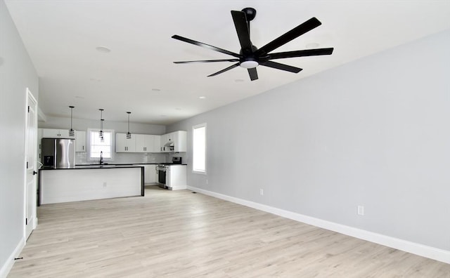 664 Mckinstry Ave, Chicopee, MA 01020 - unfurnished living room featuring a sink, light wood-style floors, a ceiling fan, and baseboards