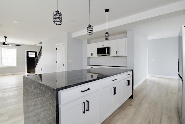 664 Mckinstry Ave, Chicopee, MA 01020 - kitchen featuring stainless steel microwave, light wood finished floors, white cabinetry, dark stone counters, and recessed lighting