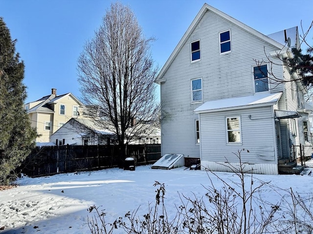 view of snow covered rear of property