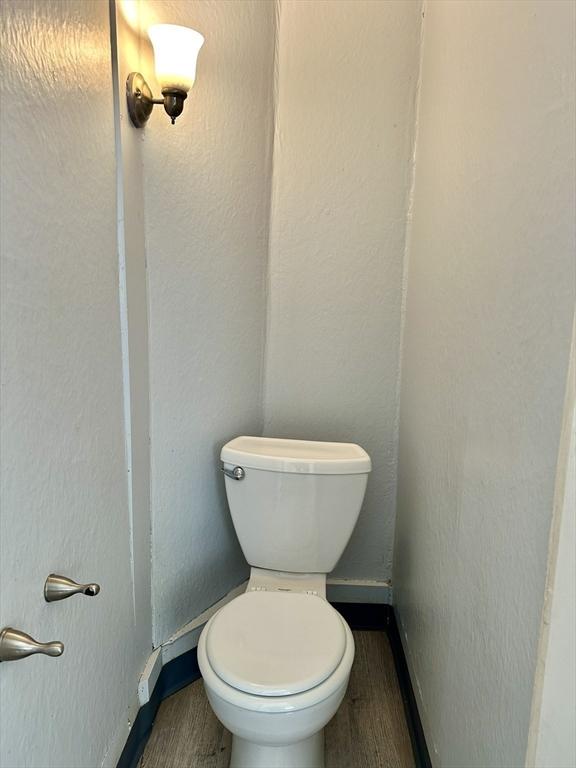 bathroom featuring wood-type flooring and toilet