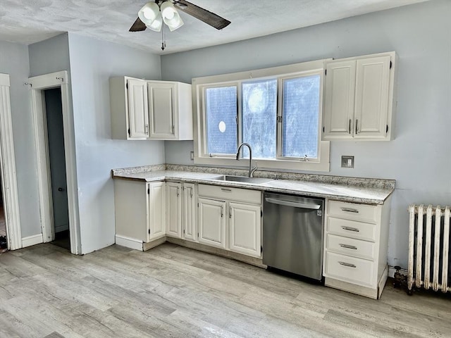 kitchen featuring radiator heating unit, sink, white cabinets, stainless steel dishwasher, and light hardwood / wood-style floors