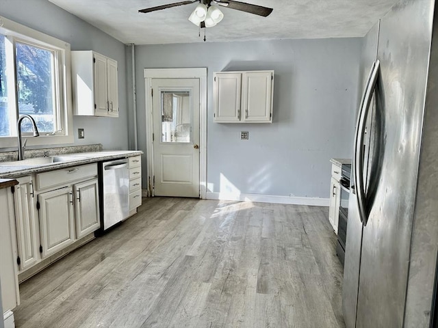 kitchen featuring appliances with stainless steel finishes, sink, light wood-type flooring, and white cabinets