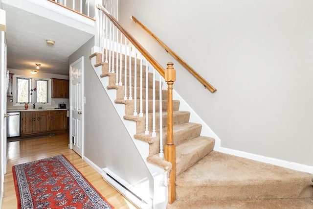 60 Spencer St Unit 60, Millis, MA 02054 - stairway featuring baseboard heating, wood finished floors, and baseboards