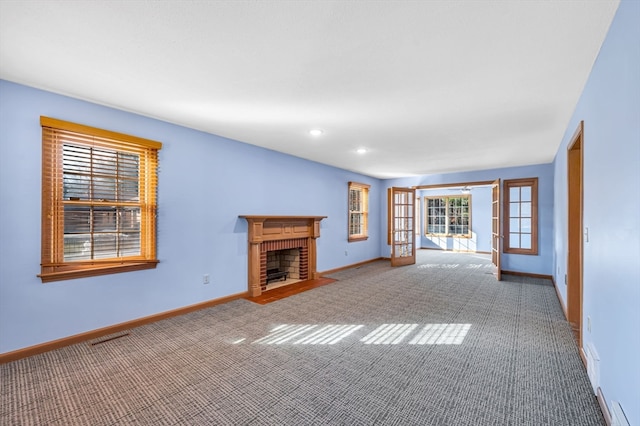 unfurnished living room featuring light carpet and a fireplace