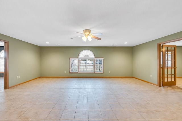 spare room featuring light tile floors and ceiling fan