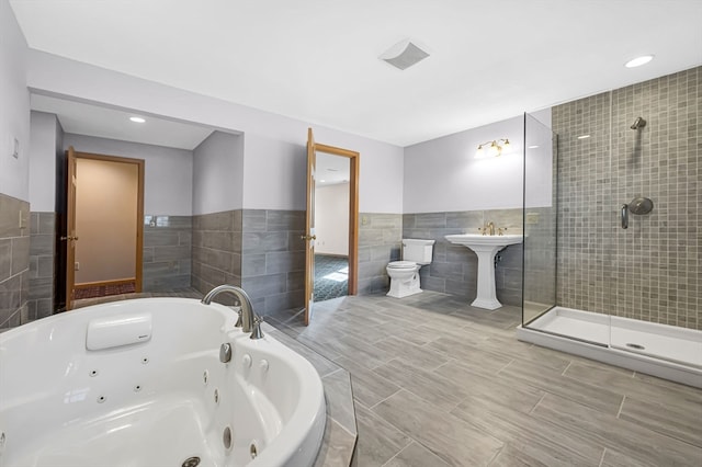 bathroom featuring an enclosed shower, tile walls, tile floors, sink, and toilet