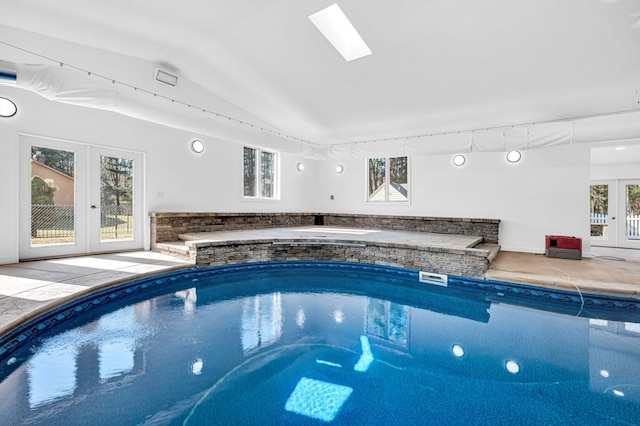 view of swimming pool with french doors and a skylight