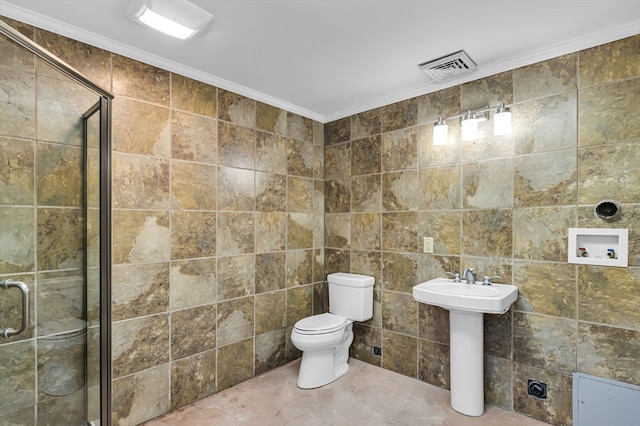 bathroom featuring tile walls, ornamental molding, toilet, and a shower with shower door