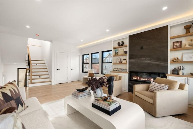 20 Clinton St Unit 22, Newton, MA 02458 - living room with stairway, a large fireplace, light wood finished floors, and recessed lighting