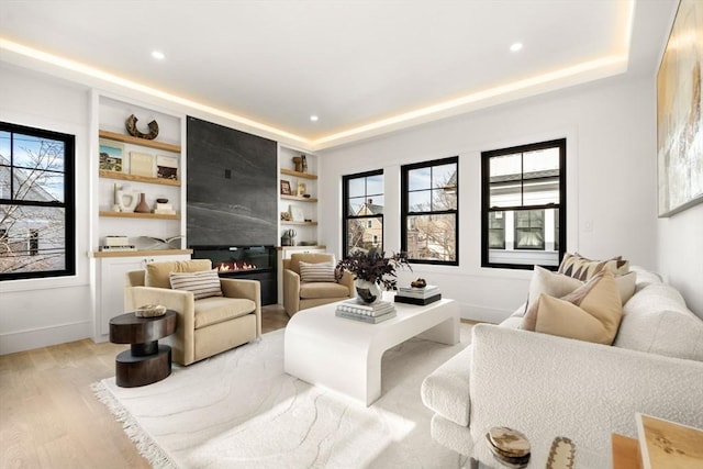 20 Clinton St Unit 22, Newton, MA 02458 - living room featuring light wood-style floors, recessed lighting, a tray ceiling, built in features, and a fireplace