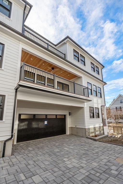 20 Clinton St Unit 22, Newton, MA 02458 - view of front of house featuring a balcony, board and batten siding, and an attached garage