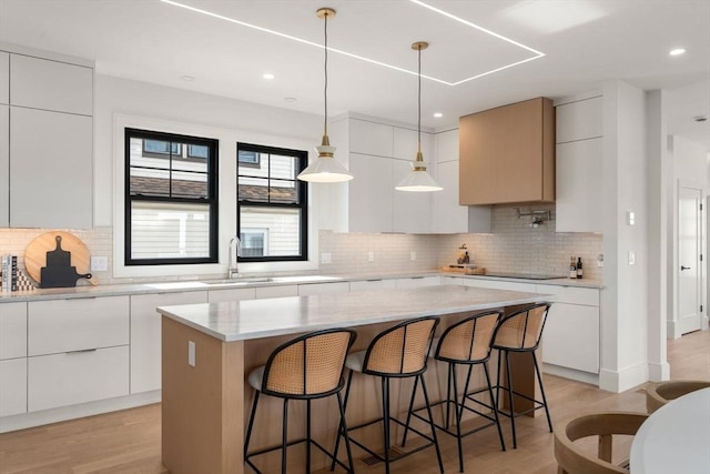 20 Clinton St Unit 22, Newton, MA 02458 - kitchen featuring modern cabinets, a kitchen island, black electric cooktop, and recessed lighting