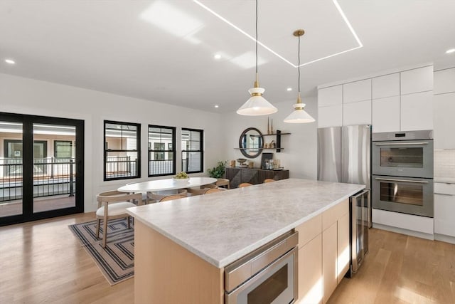20 Clinton St Unit 22, Newton, MA 02458 - kitchen with appliances with stainless steel finishes, plenty of natural light, a center island, light wood finished floors, and recessed lighting