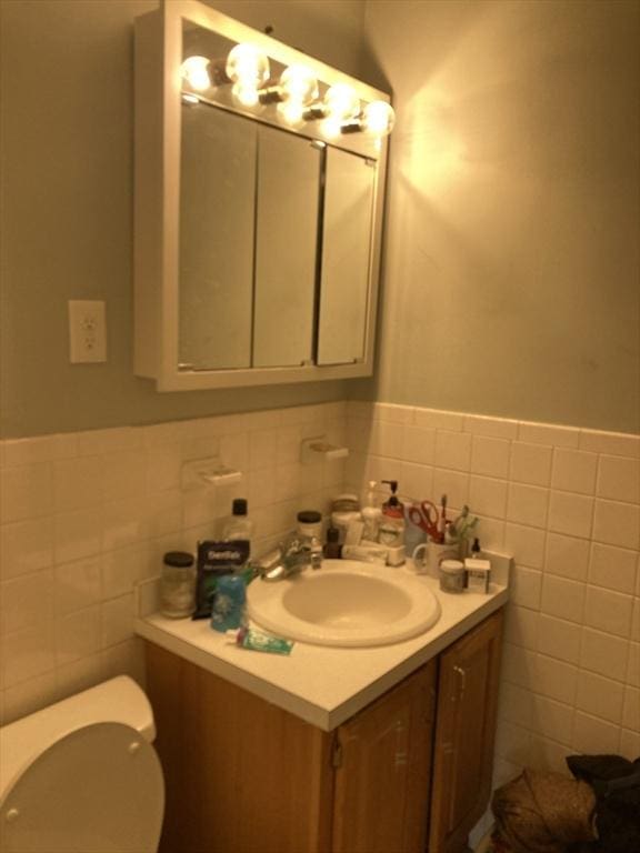 2 Summit Unit 68, Reading, MA 01867 - half bathroom featuring tile walls, vanity, and a wainscoted wall