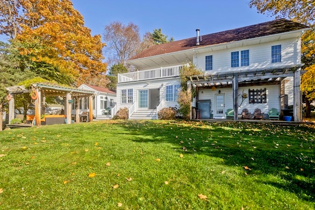 back of house featuring a pergola and a yard