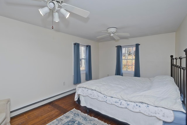 bedroom with ceiling fan, dark hardwood / wood-style floors, and baseboard heating