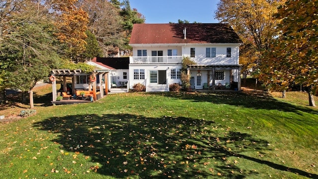 rear view of property featuring a patio, a pergola, a yard, and a balcony