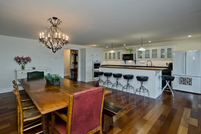 dining room featuring a chandelier, sink, and dark hardwood / wood-style floors